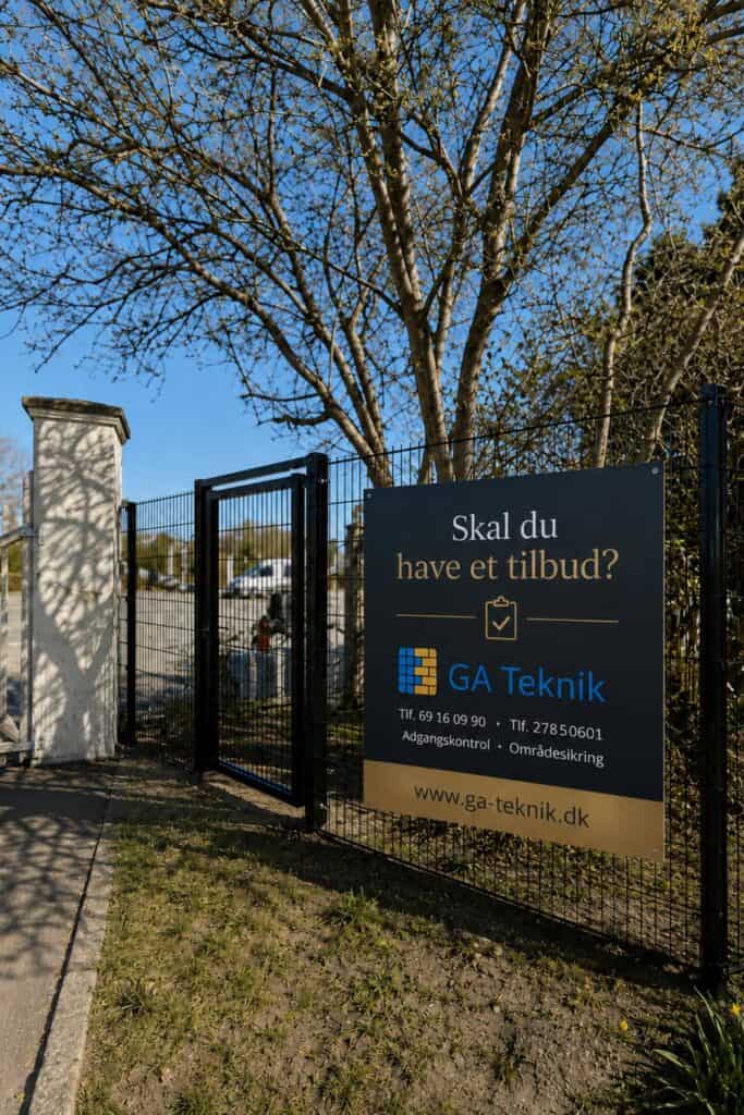 Sort hegn og skilt ved indgang til GA Teknik - "Skal du have et tilbud? GA Teknik"